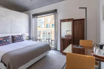 a bedroom with a bed and a desk and a window at Casa do Conto - Arts & Residence in Porto