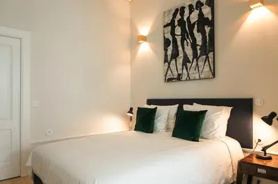 a bedroom with a large white bed with green pillows at Visconde Garden in Porto
