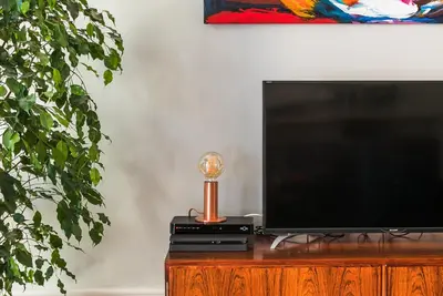 a flat screen tv sitting on top of a wooden entertainment center at Visconde Garden in Porto