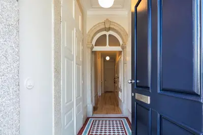 a hallway with a blue door and a tile floor at Visconde Garden in Porto