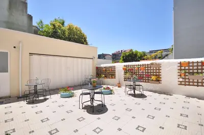 a patio with tables and chairs on a building at Porto Charming Hotel in Porto