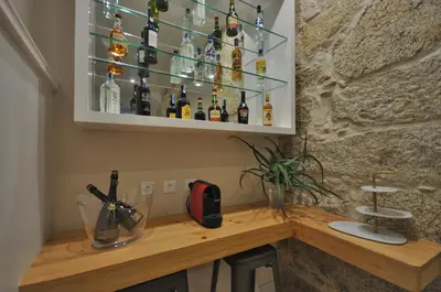 a bar with bottles of alcohol on a wall at Porto Charming Hotel in Porto