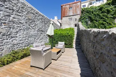 a wooden table and two chairs on a wooden deck at Oporto Gardens - Historic House, by Hopstays in Porto
