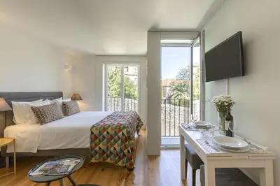 a hotel room with a bed and a balcony at Charming City Centre Studio near Aliados - Inside Porto Apartments 