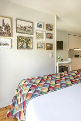 a bedroom with a bed with a colorful quilt on the wall at Charming City Centre Studio near Aliados - Inside Porto Apartments 