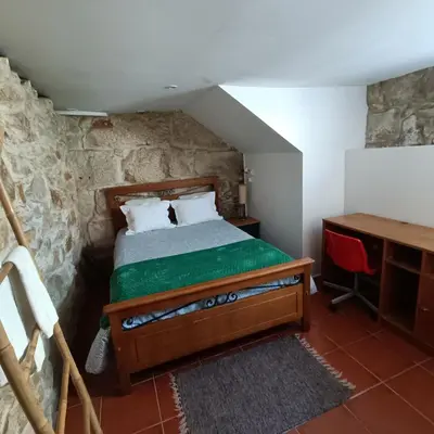 a bedroom with a bed and a desk in a room at Guesthouse Monsanto in Porto