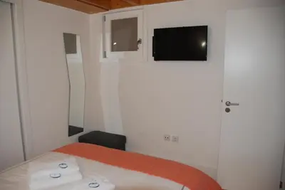 a bedroom with a bed and a tv on the wall at OportoView Premium Apartment in Porto