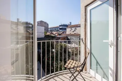 a chair on a balcony with a view of a city at Formosa 79 Apartments by Guestify in Porto