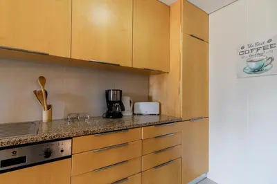 a kitchen with wooden cabinets and a counter top at D João IV Apartment With Terrace by LovelyStay in Porto