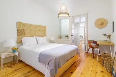 a bedroom with a large white bed and a desk at Own Places Cedofeita Apartments in Porto