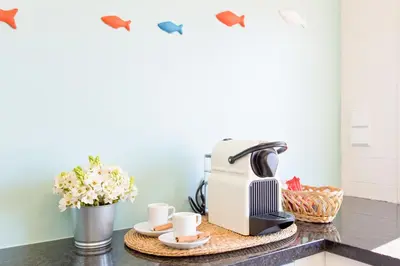 a coffee maker on a counter with cups and flowers at Own Places Cedofeita Apartments in Porto