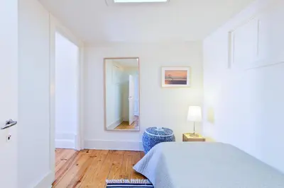 a white bedroom with a bed and a mirror at Own Places Cedofeita Apartments in Porto