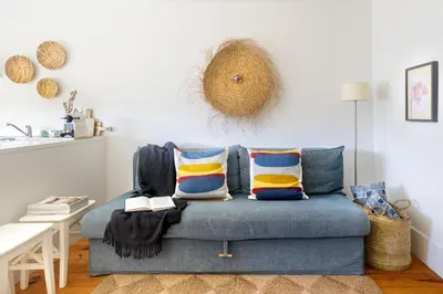 a living room with a blue couch with pillows at Own Places Cedofeita Apartments in Porto
