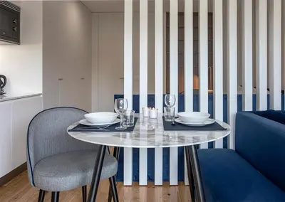 a dining table with two chairs and a table with glasses at ORM - Mártires & Pinheiro Apartments in Porto