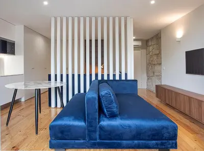 a blue couch in a living room with a table at ORM - Mártires & Pinheiro Apartments in Porto