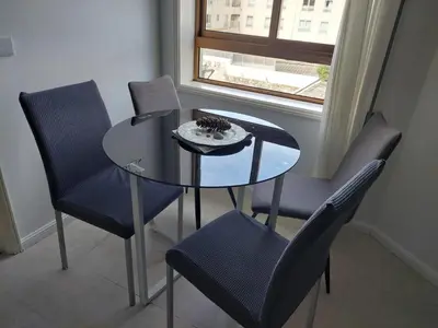 a dining table and chairs with a glass table and a window at Comfort in the Downtown in Porto