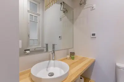 a bathroom with a white sink and a mirror at APorTo - 2 Suites in Porto