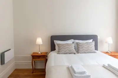 a bedroom with a large white bed with two lamps at APorTo - 2 Suites in Porto