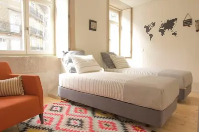 a bedroom with two beds and a couch and a map on the wall at Taipas Plaza @ Historical Center in Porto