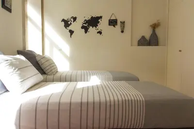 a bedroom with two beds and a world map on the wall at Taipas Plaza @ Historical Center in Porto