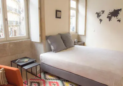 a bedroom with a bed and a world map on the wall at Taipas Plaza @ Historical Center in Porto