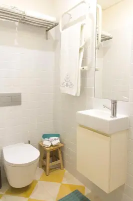 a white bathroom with a toilet and a sink at Taipas Plaza @ Historical Center in Porto