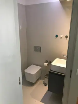 a white bathroom with a toilet and a sink at Lux Bolhão - ALL INCLUDED in Porto