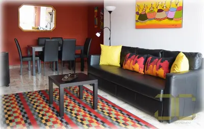 a living room with a black couch and a table at Learn Porto Apartment by JC in Porto