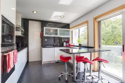 a kitchen with a black counter and red stools at Pretty Porto Apartment by SOULSHARING.PORTO in Porto