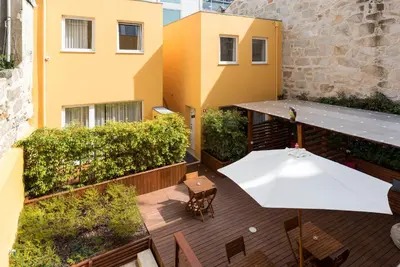 a balcony with a white table and chairs and a building at Bloom House by Sweet Porto in Porto