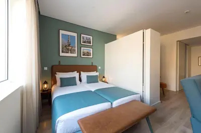 a bedroom with a large bed and a blue wall at Bloom House by Sweet Porto in Porto