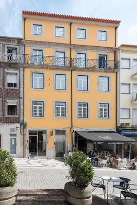 a large yellow building with tables and chairs in front of it at Bloom House by Sweet Porto in Porto