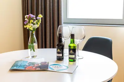 a table with two wine glasses and a book and flowers at Feel Porto Codeçal Apartments in Porto