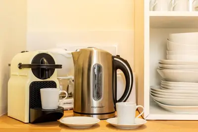 a coffee maker and cups on a kitchen counter at Feel Porto Codeçal Apartments in Porto