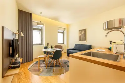 a kitchen and living room with a sink and a table at Feel Porto Codeçal Apartments in Porto