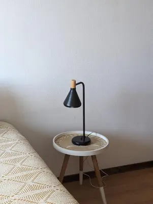 a lamp sitting on a table next to a bed at Pine Tree Apartment in Porto