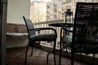 a balcony with two chairs and a table and a window at Origami Porto Residência & Hostel in Vila Nova de Gaia
