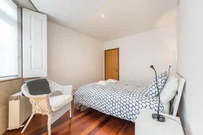 a bedroom with a bed and a chair at GuestReady - Ao Coliseu in Porto
