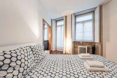 a bedroom with a large bed with two towels on it at GuestReady - Ao Coliseu in Porto