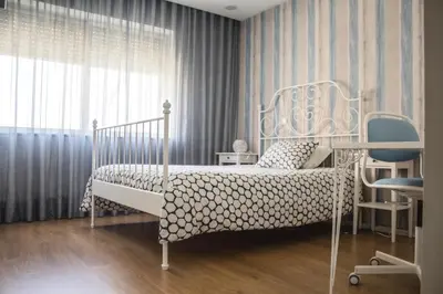 a bedroom with a white bed and a chair at Amazing Amial in Porto
