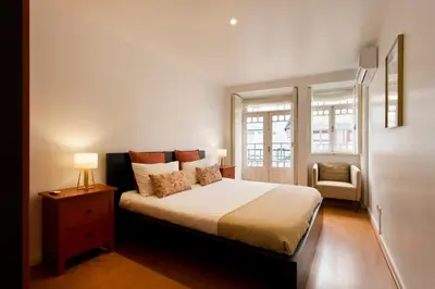 a bedroom with a bed and a chair in it at Home @ Porto Clérigos Apartment in Porto