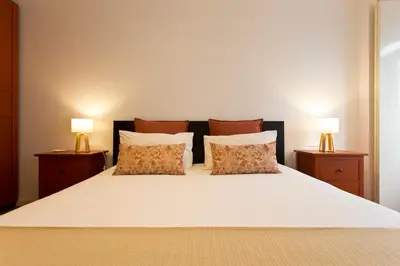a bedroom with a white bed with two lamps at Home @ Porto Clérigos Apartment in Porto