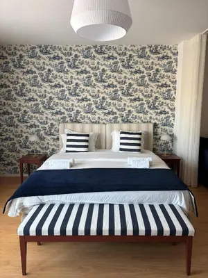 a bedroom with a large bed with a floral wallpaper at Be Oporto Apartments Clérigos in Porto