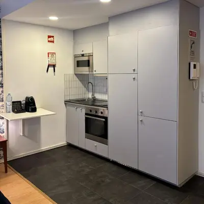 a kitchen with white cabinets and a stove at Be Oporto Apartments Clérigos in Porto