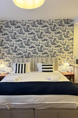a bedroom with a large bed with a blue and gray wallpaper at Be Oporto Apartments Clérigos in Porto