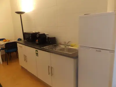 a kitchen with a white refrigerator and a sink at Casa do Largo in Porto