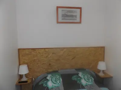 a bed with two lamps and a picture on the wall at Casa do Largo in Porto
