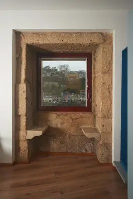 a brick wall with a window in a room at Bridge It - Suites & Views in Vila Nova de Gaia