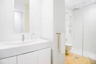 a white bathroom with a sink and a shower at Blue House Porto Apartments - Parking in Porto