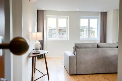 a living room with a couch and a table with a lamp at Blue House Porto Apartments - Parking in Porto